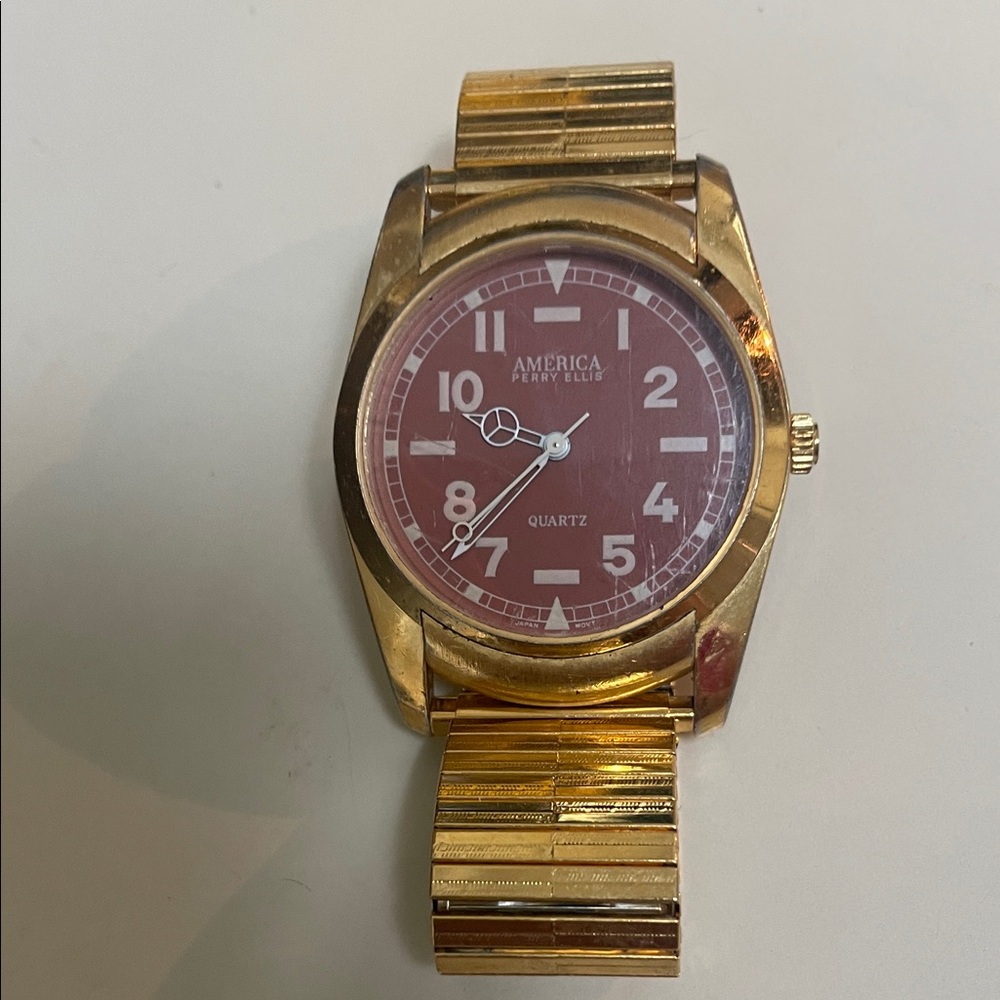 Perry Ellis Gold-Tone Watch with red dial -pre-owned needs battery.